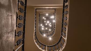A spiral staircase with ornate metal railings and a series of lights at the top.