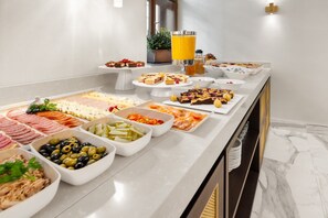 Un bufé con diferentes opciones de comida y un dispensador de zumo.