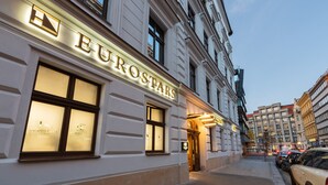 Un bâtiment arborant une enseigne lumineuse « EUROSTARS », doté de grandes fenêtres et présentant un style architectural classique.