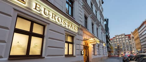 Un edificio con el cartel iluminado "EUROSTARS", con grandes ventanales y un estilo arquitectónico clásico.