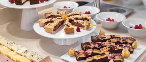 Un bufé con diversos postres y quesos.