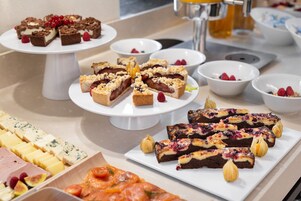 Um buffet com diversos doces e queijos.