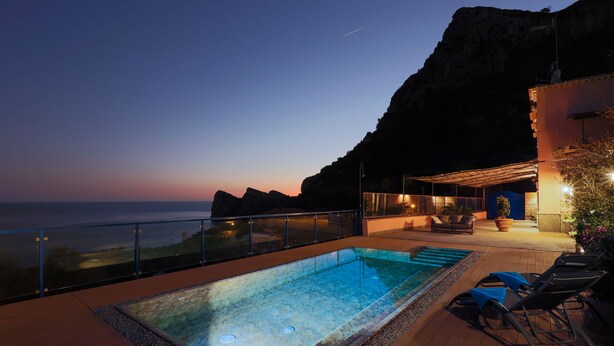 A rooftop pool with a view of the ocean at dusk. - Villa The Phoenix (Massa Lubrense)