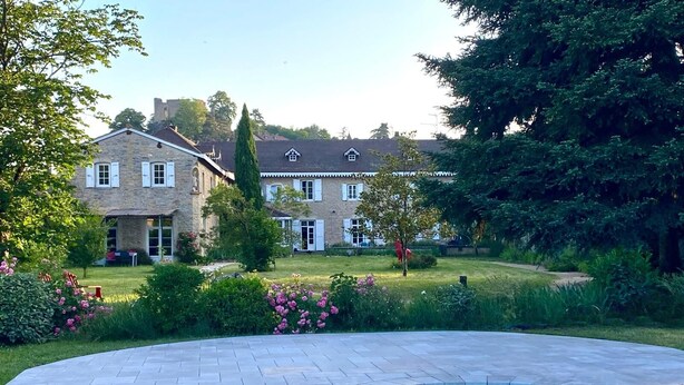 A swimming pool with a stone patio, a large stone building with multiple windows, and a well-maintained lawn. - Le Clos Ayanna (Crémieu)