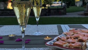 Two glasses of white wine on a table with a plate of smoked salmon and toast. - Le Clos Ayanna (Crémieu)