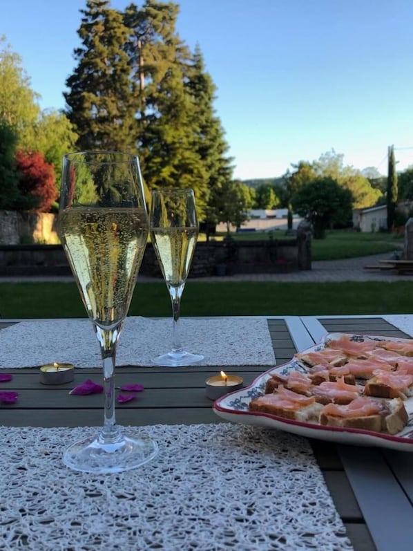 Two glasses of white wine on a table with a plate of smoked salmon and toast.