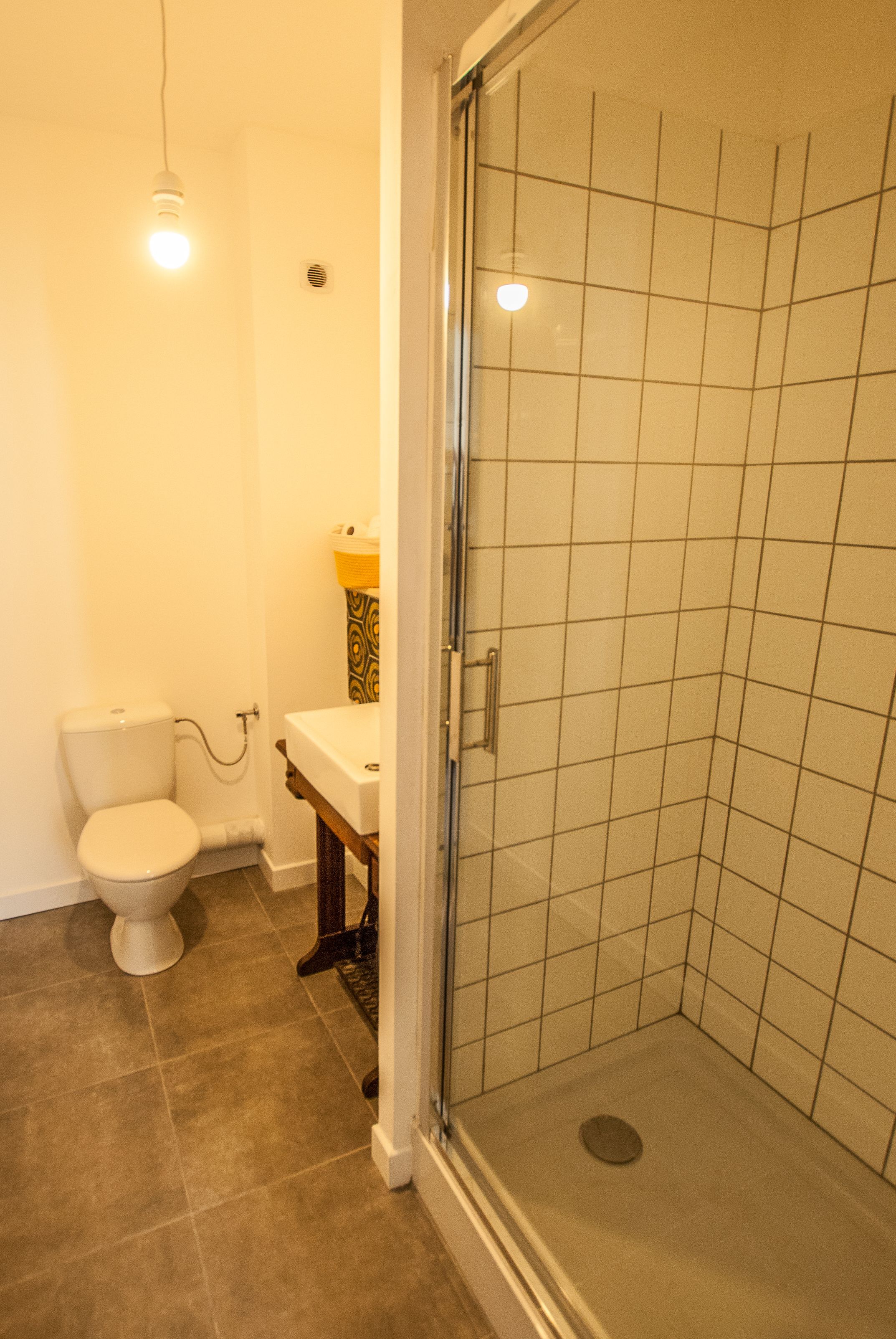 Un bagno con il water, lavandino e doccia.