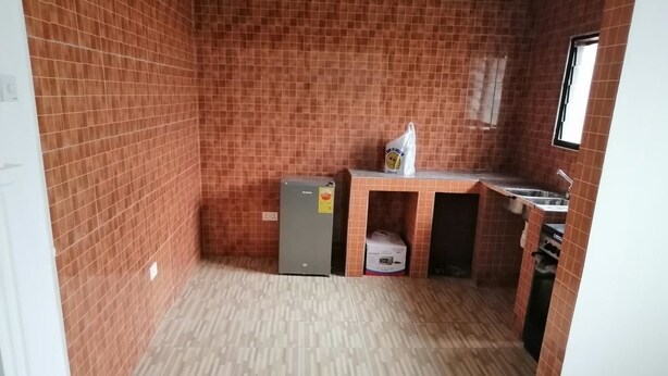 A compact kitchen with a refrigerator, sink, and tiled walls. - Salomey Plaza (Kwabenya)