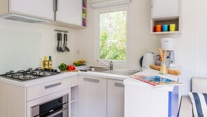 Una cocina moderna con estufa a gas, horno, pileta y ventana.