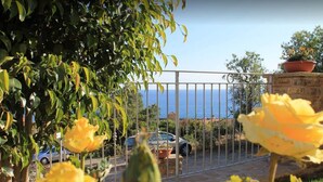 A balcony with a view of the sea, a car parked in the background, and a potted plant on the right. - Cilento Holiday Village (Montecorice)
