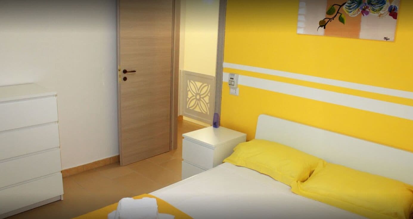Une chambre d’hôtel avec un lit, une table de chevet, une armoire et une porte.