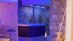 A modern interior with a stone wall, a fireplace, and a wooden bench. - Cilento Holiday Village (Montecorice)