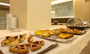 A buffet table with various pastries and bread, including tarts and croissants, on a white tablecloth. - Hotel Paradiso Terme (Abano Terme)