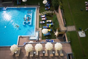 Piscine couverte, piscine extérieure, parasols de plage, chaises longues