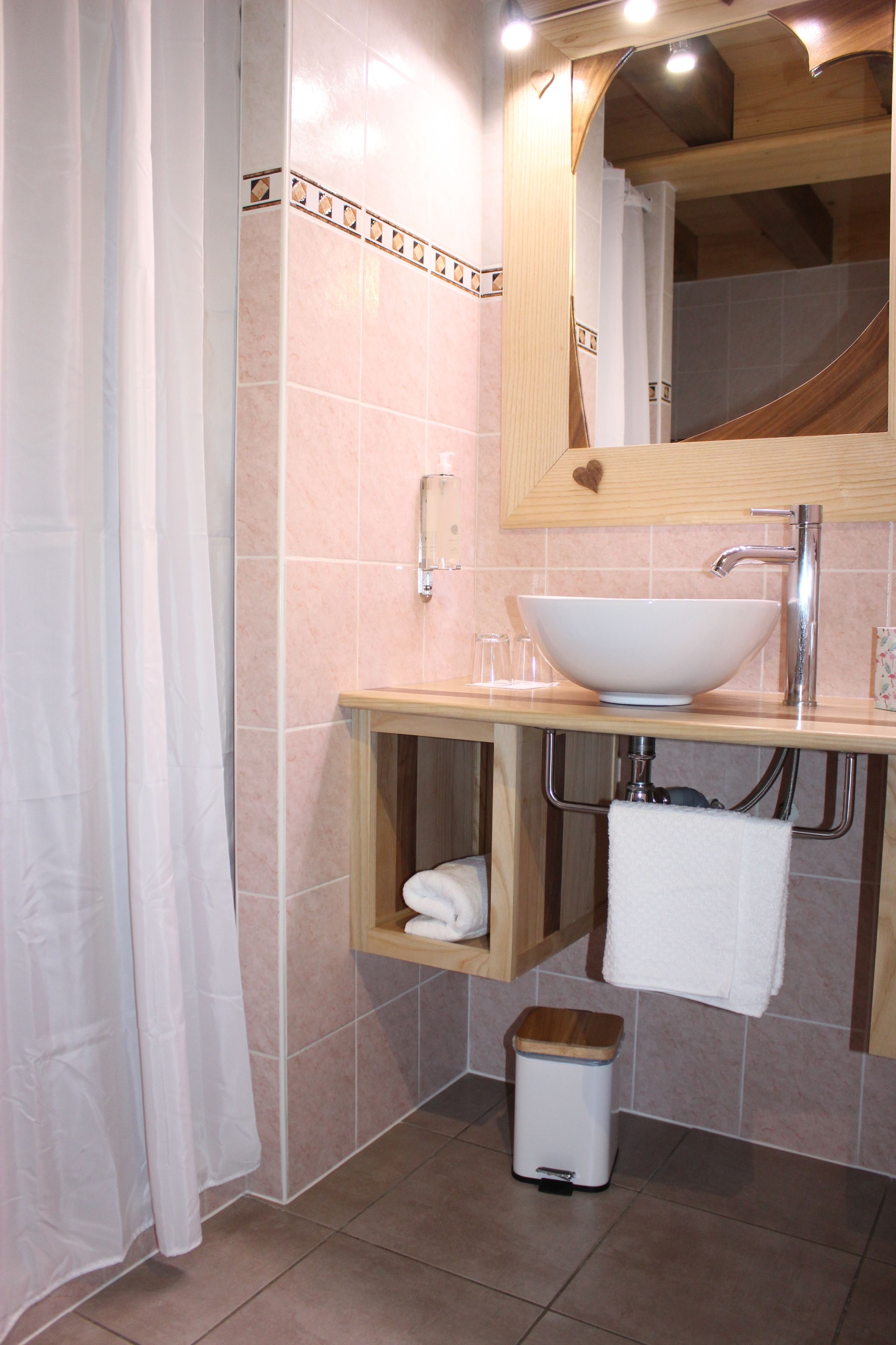 Ein Badezimmer mit Waschbecken, Spiegel und Duschvorhang.