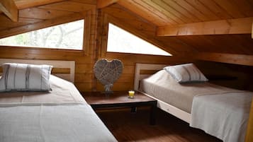 A cabin with two beds, a heart-shaped decoration, and a small table with a glass of juice.