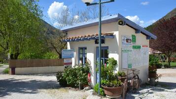 A small building with a signboard, a reception desk, and a bicycle parked outside.