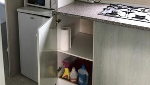 A compact kitchenette with a microwave, coffee maker, and gas stove. - Calme et Nature (Saint Sever)