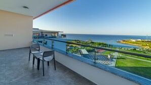 A balcony with a view of the sea, a pool, and a beach area. - Lonicera Premium (Alanya)