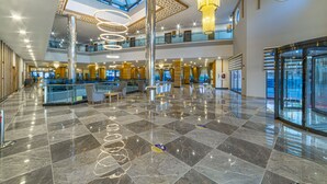 A spacious lobby with a high ceiling, a central chandelier, and a check-in counter. - Lonicera Premium (Alanya)