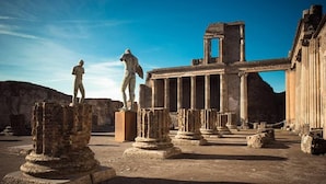 Ruinas antiguas con columnas y estatuas.