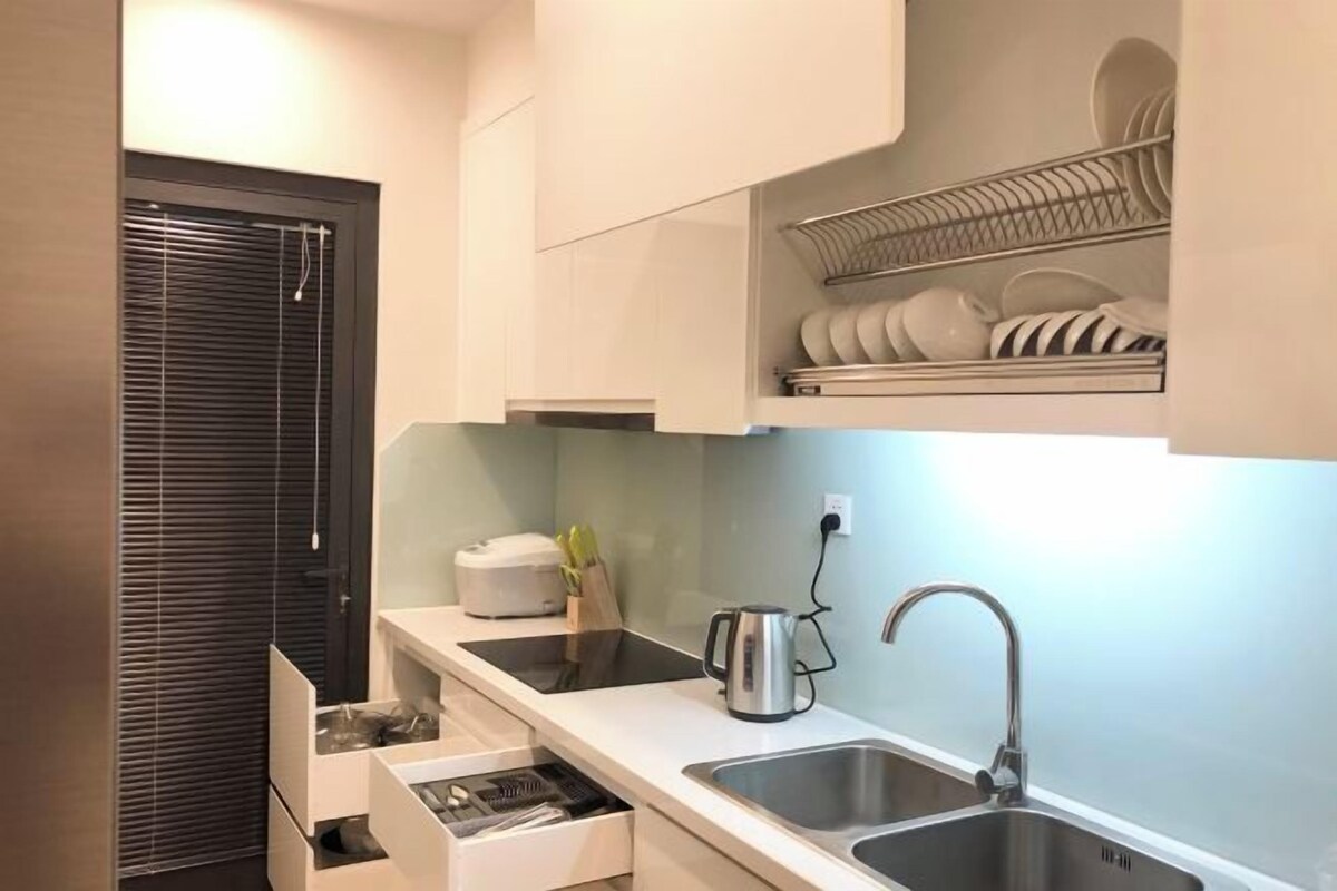 A modern kitchen with a built-in oven, two stainless steel sinks, and a dish rack above the counter.