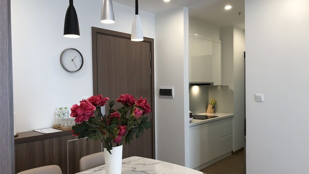 A modern kitchen with white cabinets, a built-in oven, and a microwave. - Luxury Condotel Vinhomes Skylake Keangnam (Hanoi)