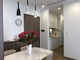 Una cocina moderna con armarios blancos, horno empotrado y microondas.