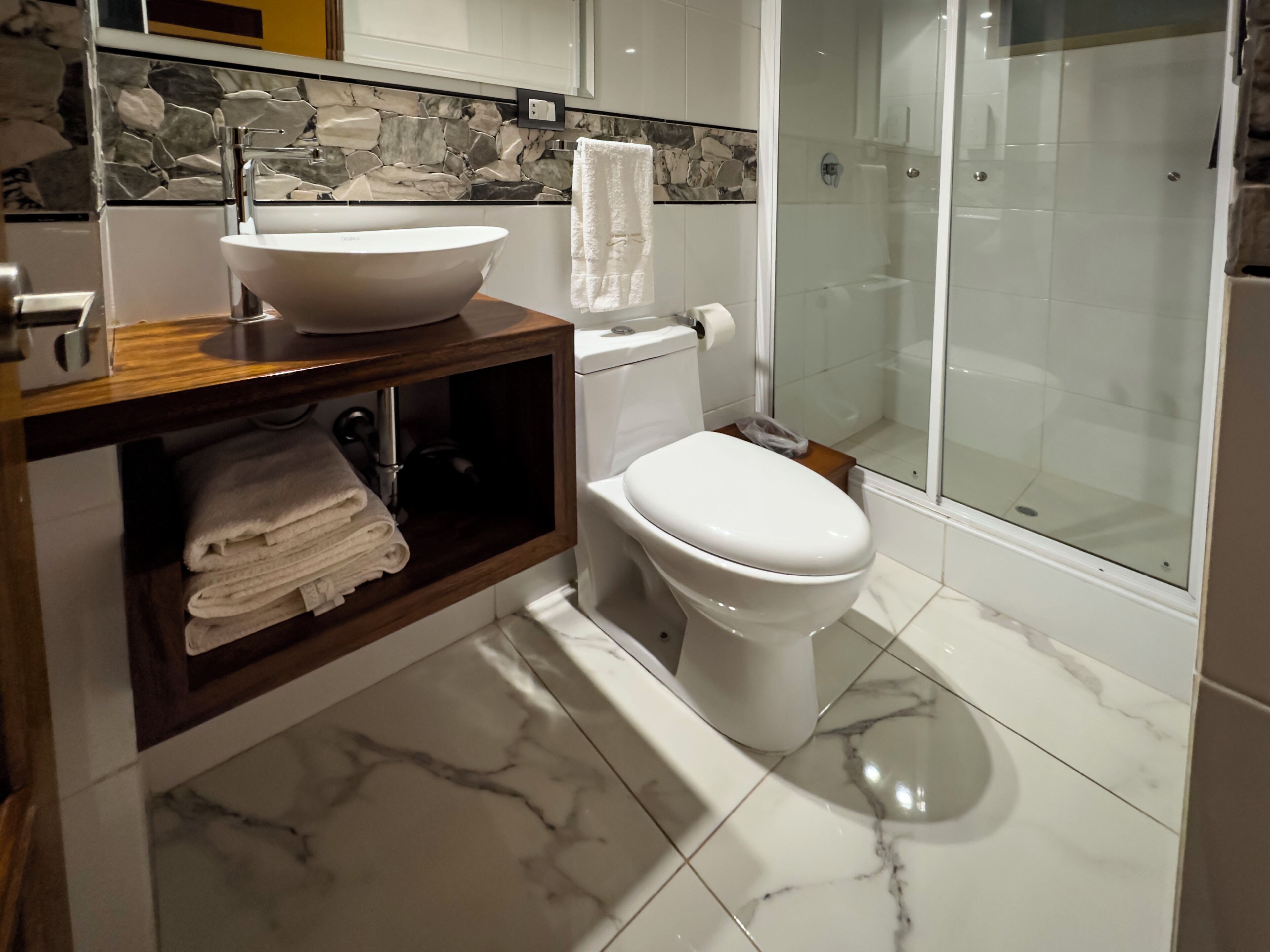 A bathroom with a freestanding bathtub, a toilet, and a glass-enclosed shower.