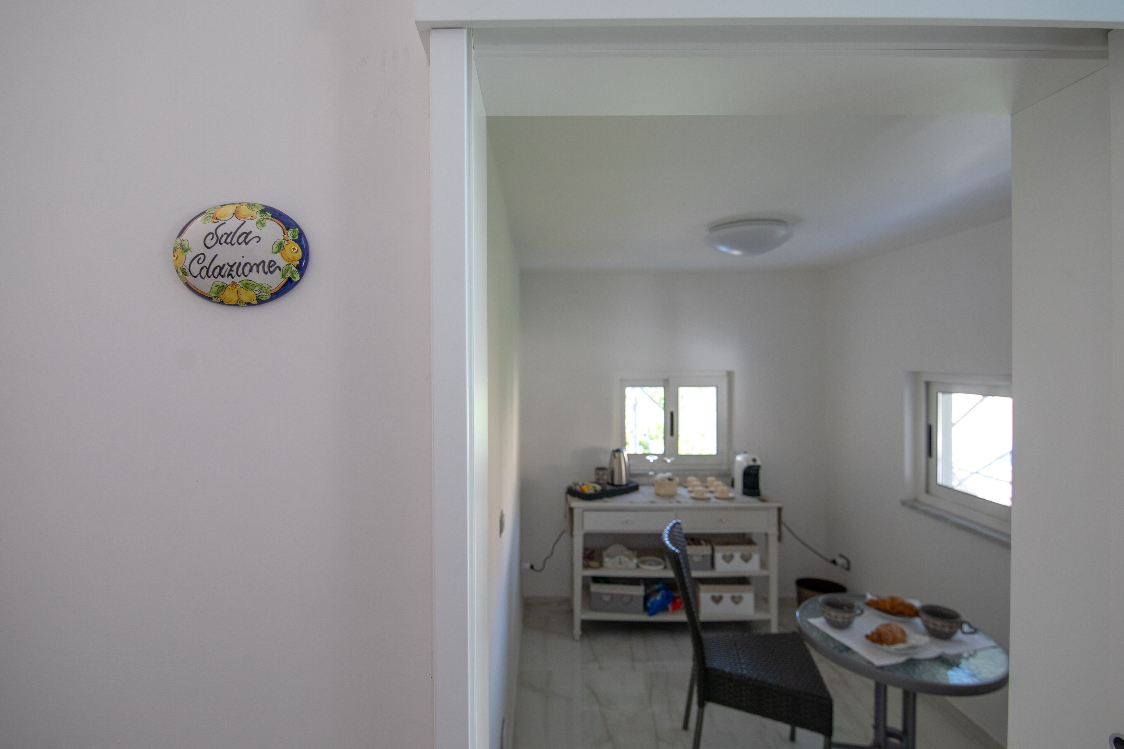 Una cocina con una mesa de comedor, sillas y una encimera con alimentos.