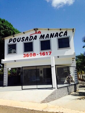 A two-story building with a sign reading "POUSADA MANACA" and a phone number "3608-1617".