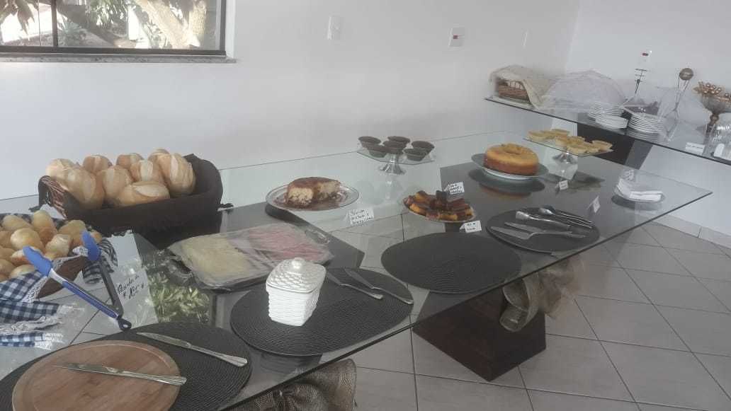 A buffet setup with various food items and utensils on a glass table.