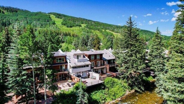 A large, multi-story building surrounded by dense forest and a river. - Texas Townhome Condos - 3 Minutes Walk to Gondola by RedAwning (Vail)