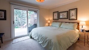 A bedroom with a large bed, a sliding glass door to a balcony, and a ceiling light fixture. - Texas Townhome Condos - 3 Minutes Walk to Gondola by RedAwning (Vail)