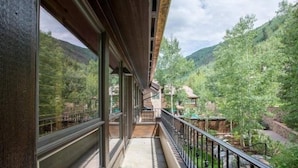 A balcony with a view of a forested valley. - Northwoods Luxury Condo Close to Chairlift by RedAwning (Vail)