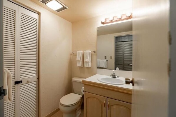 A bathroom with a toilet, sink, mirror, and towel rack. - Villa Cortina Condo 5 Minutes Walk to Vail Village by RedAwning (Vail)