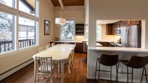 Una cocina moderna con una isla grande, piso de madera y vistas al exterior.