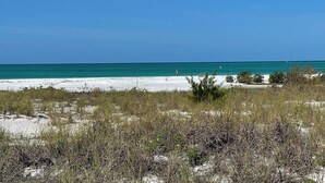 A beach with white sand and clear turquoise water. - 763 North Shore Downstairs 3 Bedroom Apts by RedAwning (Anna Maria)