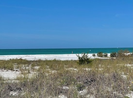 A beach with white sand and clear turquoise water.