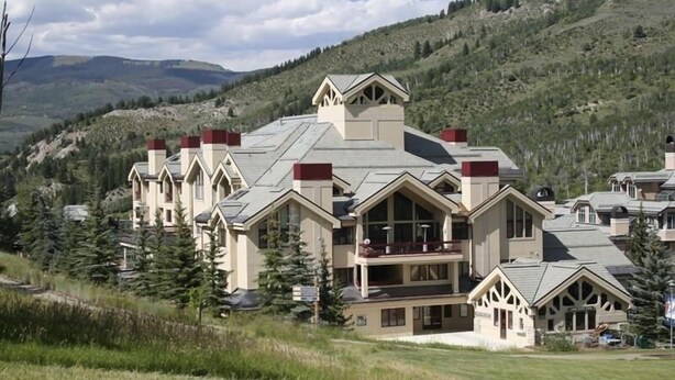 Ein großes Resort mit mehreren Gebäuden, darunter ein markantes Hauptgebäude mit Balkon und ein kleinerer Anbau.