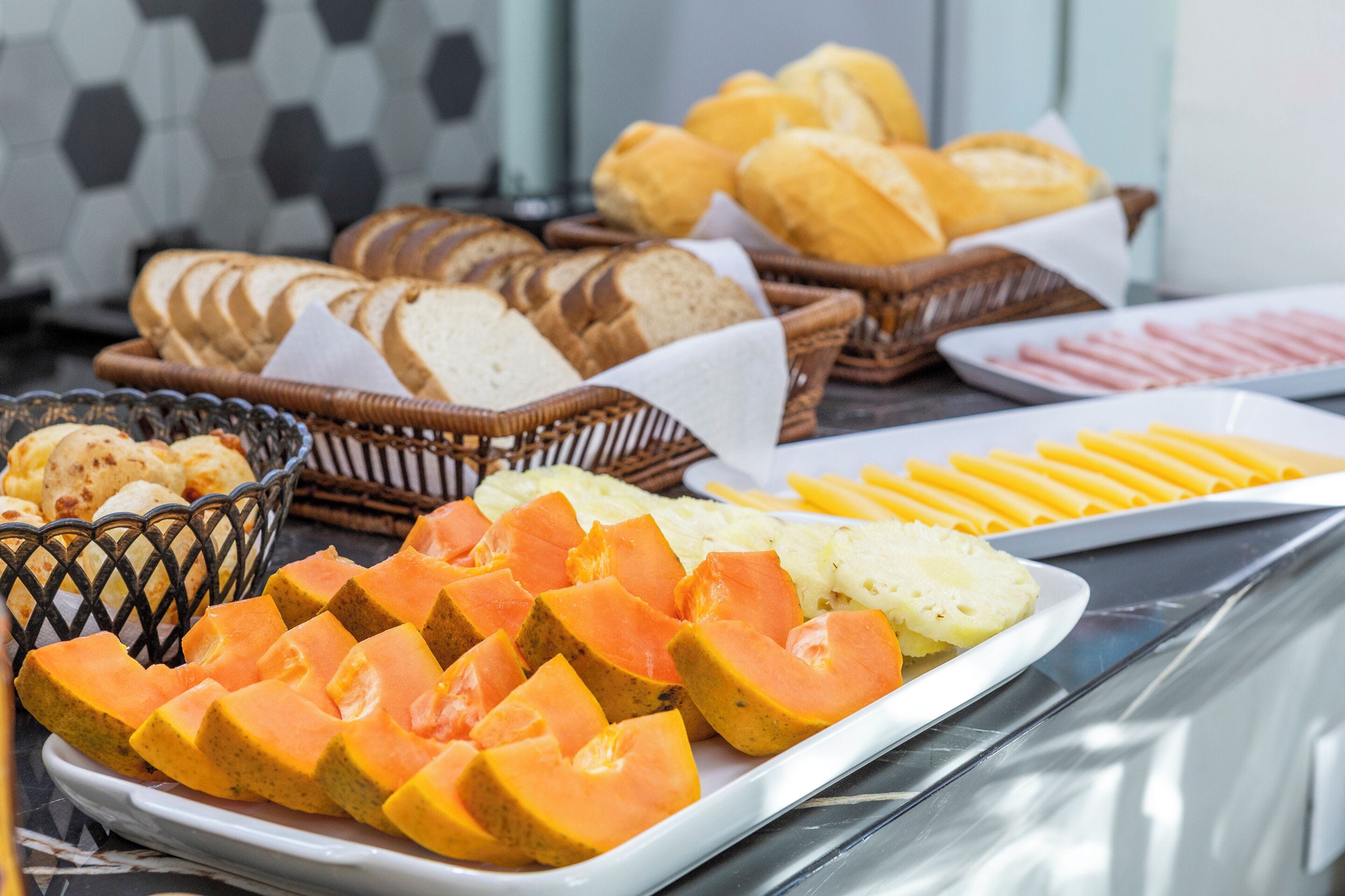 Ein Buffet mit geschnittenen Früchten, Brot und verschiedenen Speisen.