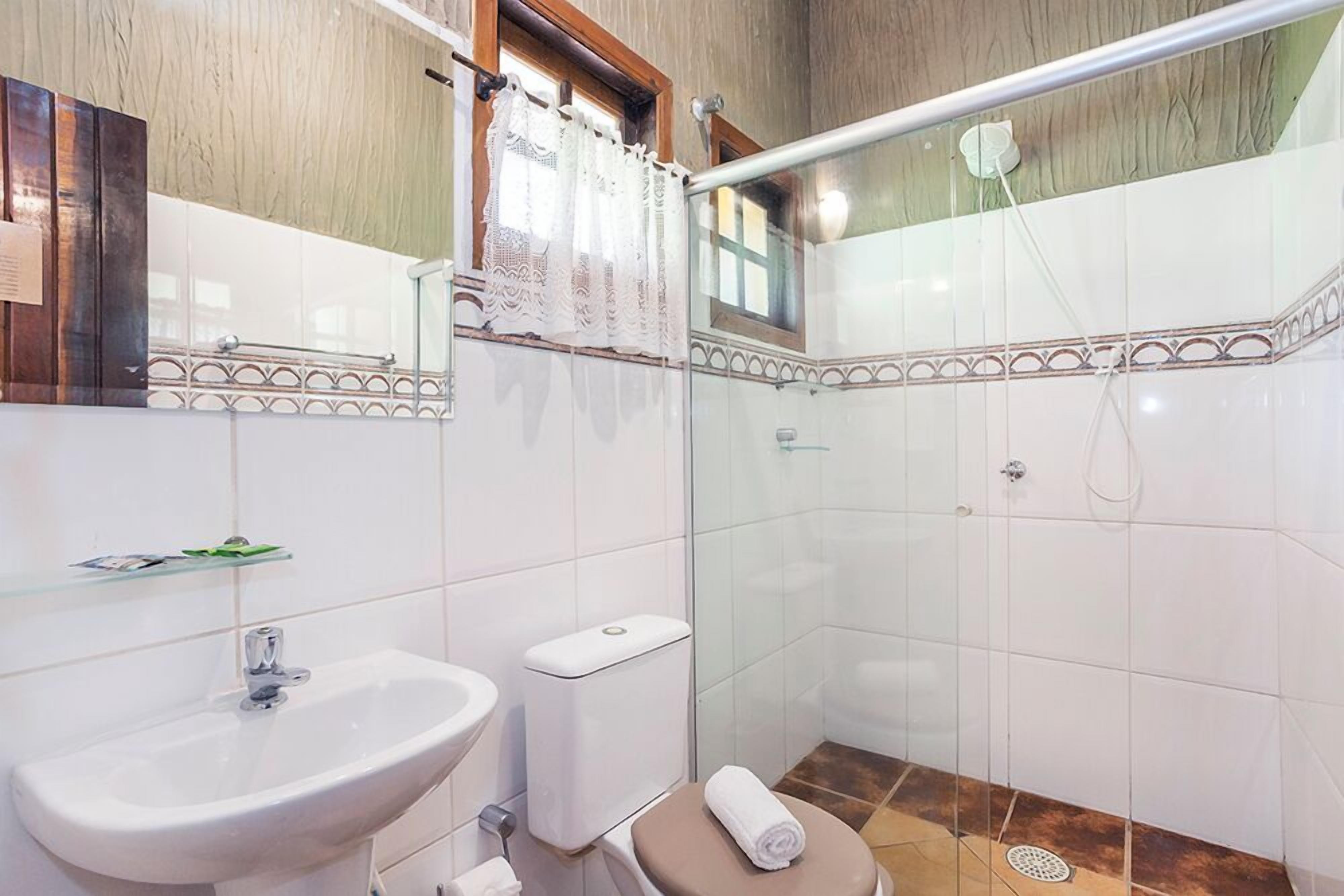Une salle de bain avec un lavabo, des toilettes et une douche.