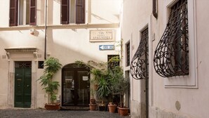 A narrow cobblestone street with a building entrance, potted plants, and a sign indicating 'VIA R.VIII DEGLI SPAGNOLI'. - Cozy Apartment in via Degli Spagnoli, Pantheon (Rome)