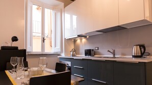 A modern kitchen with a dining area, featuring a window, stainless steel appliances, and a clean layout. - Cozy Apartment in via Degli Spagnoli, Pantheon (Rome)