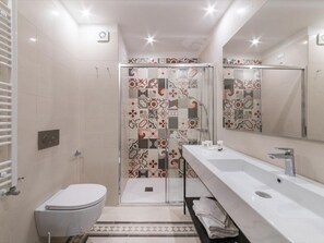 A modern bathroom with a toilet, shower, and sink. - Panisperna Apartment 4 (Rome)