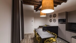 Una cocina moderna con comedor, que presenta un techo de madera, un microondas integrado y una mesa de comedor con sillas amarillas.