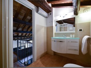 A bathroom with a glass sink, white cabinets, a mirror, and a shower. - Ibernesi 1 Apartment (Rome)
