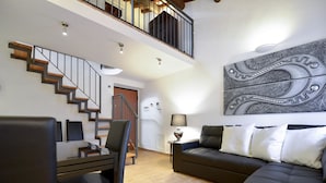 Una sala de estar moderna con una escalera, un sofá y una zona de comedor.