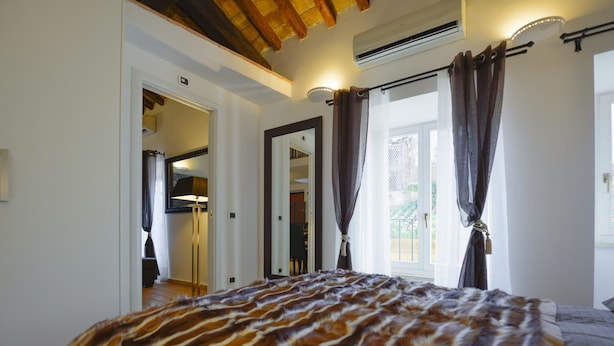 Un dormitorio con una cama grande, un ventilador de techo y una ventana con cortinas.