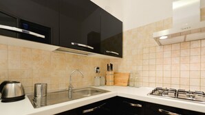 Una cocina moderna con gabinetes negros, un lavamanos de acero inoxidable y una estufa a gas.